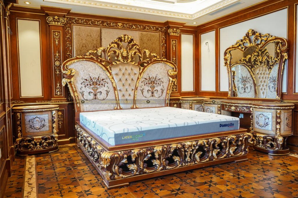 Phòng ngủ với giường hoàng gia phủ gỗ gõ đỏ, ánh sáng đèn chùm tinh tế.