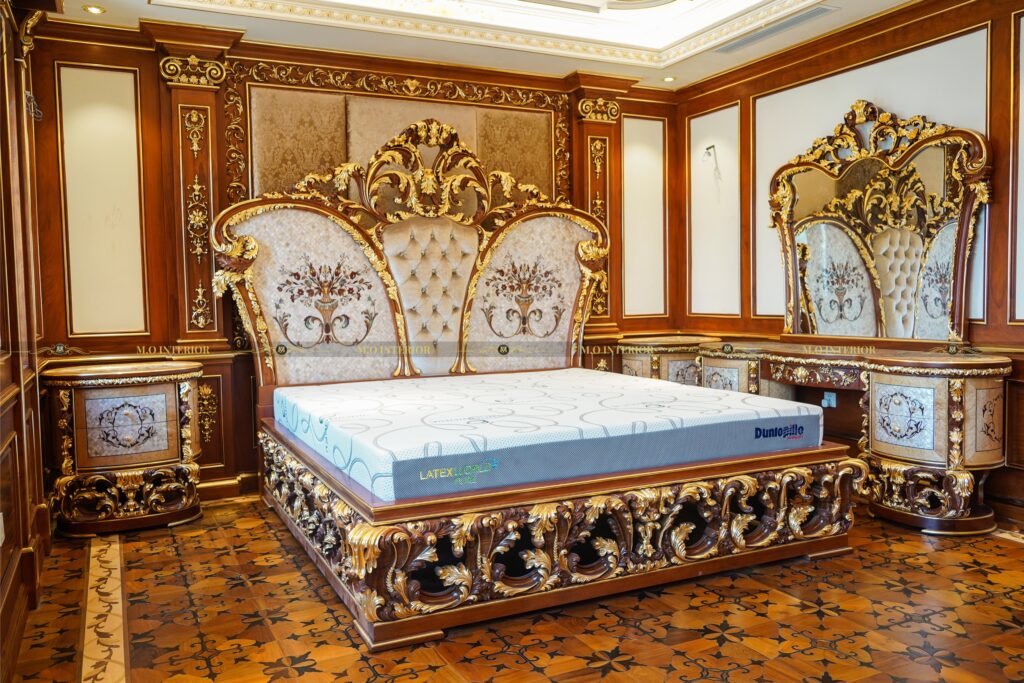 Phòng ngủ với giường hoàng gia phủ gỗ gõ đỏ, ánh sáng đèn chùm tinh tế.